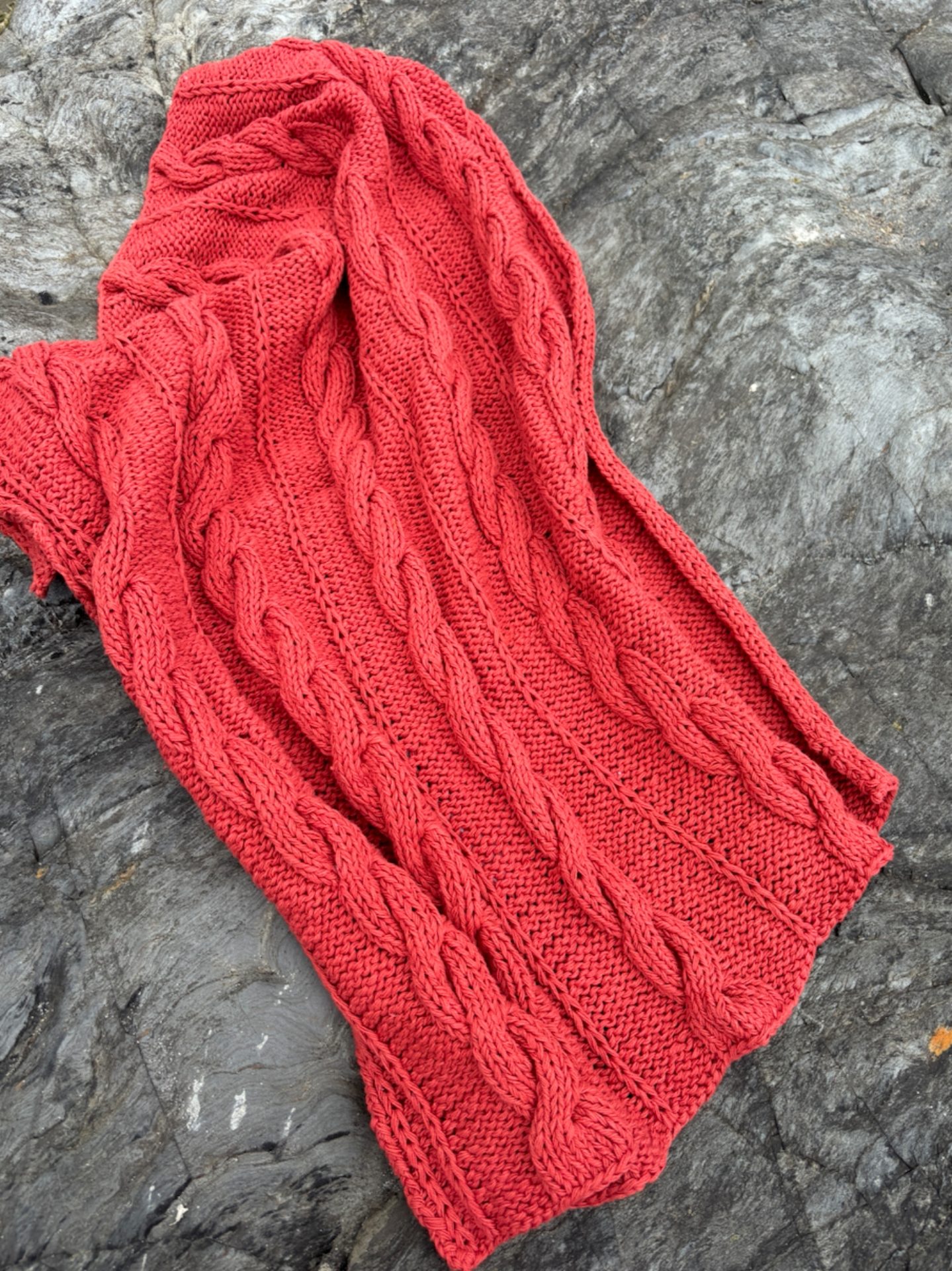 image shows hand knitted natural paprika red baby Charlie blanket