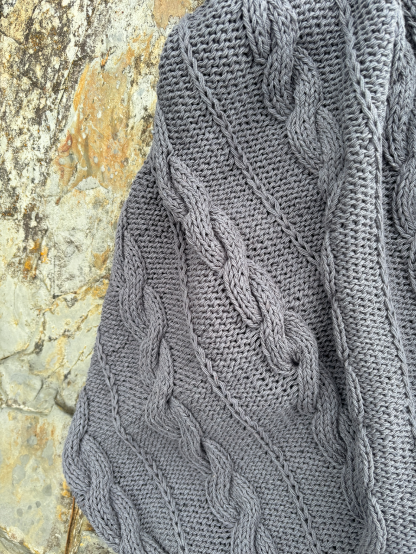 image shows hand knitted natural organic stromy blue grey baby Charlie blanket
