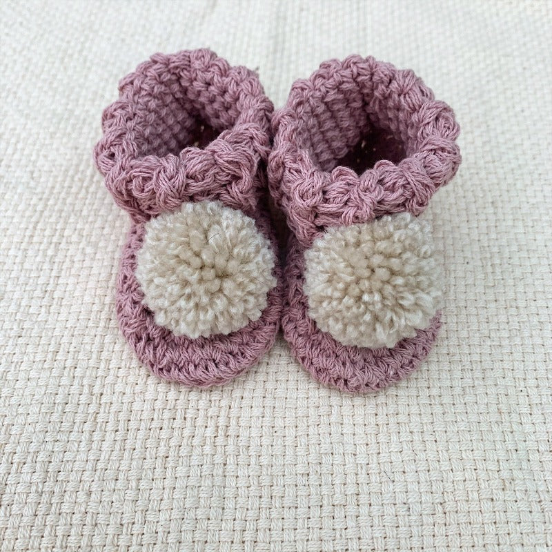 image shows a pair of pink organic cotton baby booties
