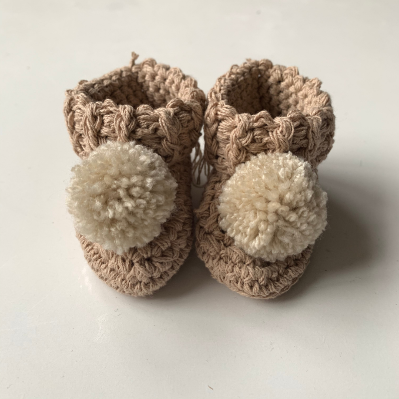 image shows a neutral pair of organic cotton baby booties.