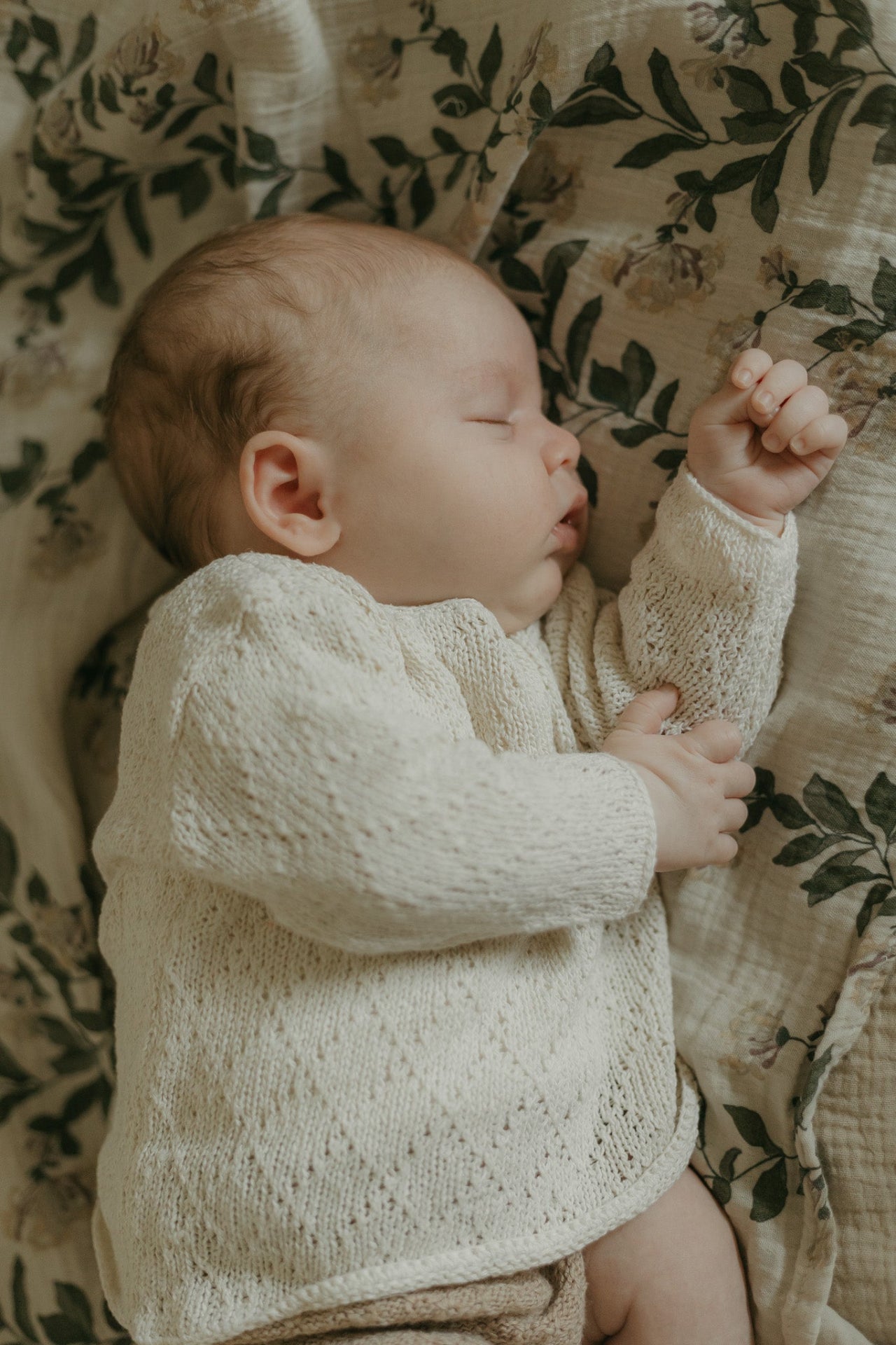 image shows baby wearing organic silk natural cream diamond knit
