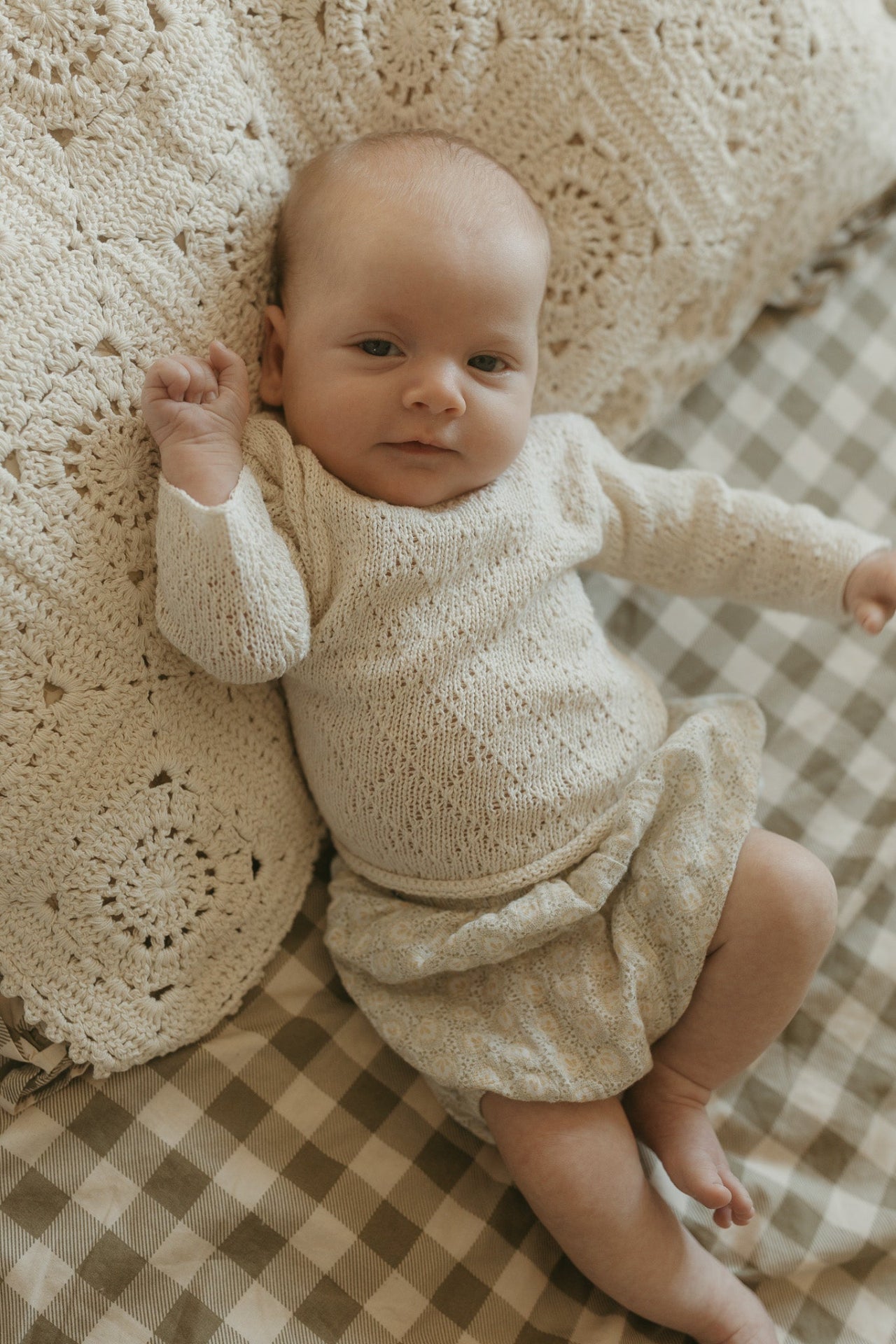 image shows baby wearing natural cream silk diamond knit