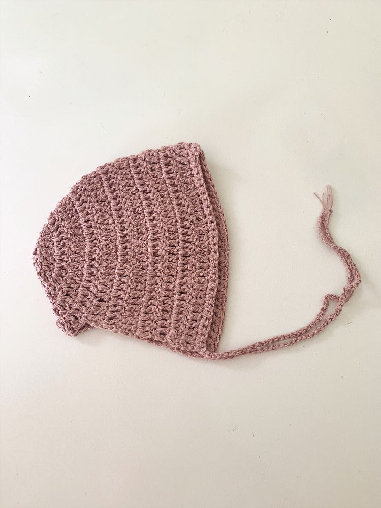image shows a pink organic cotton baby bonnet