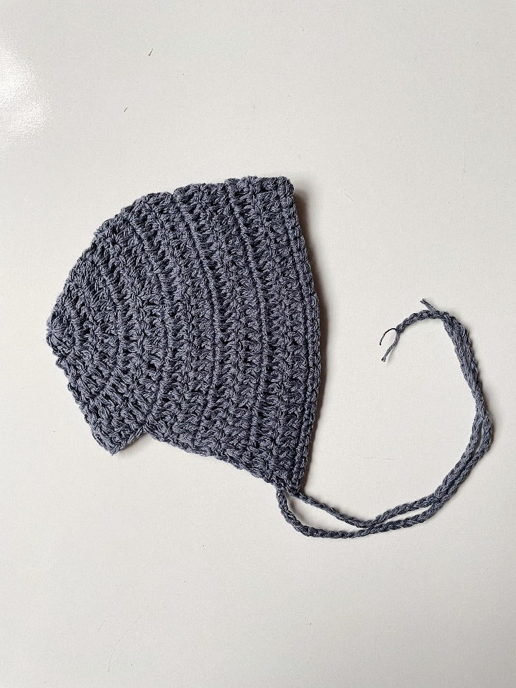 image shows a blue organic cotton baby bonnet